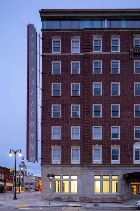 A tall red brick building with a sign that says "Theatricorn" on it.