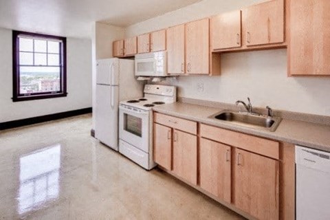 A kitchen with white appliances and wooden cabinets.