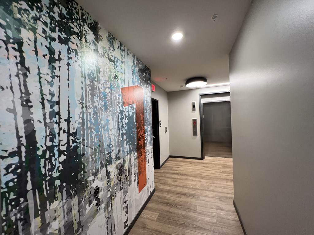 a hallway with a large painting on a wall and a door