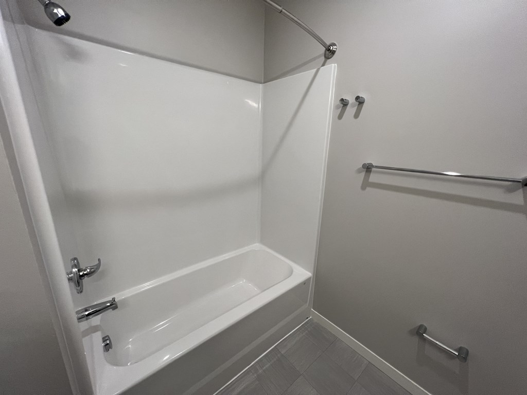 a white bathroom with a shower and a sink