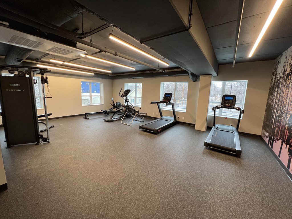 a fitness room with treadmills and other exercise equipment