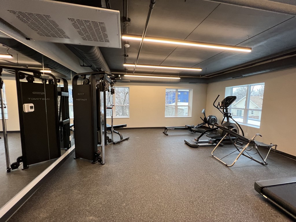 an empty gym with exercise equipment and mirrors