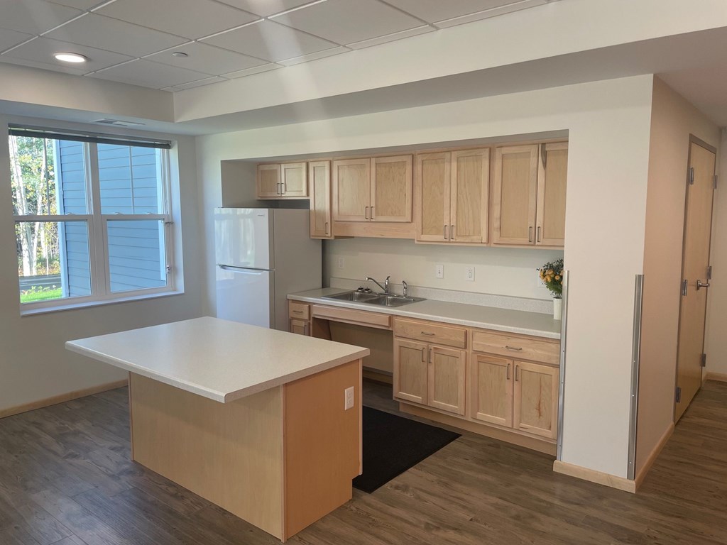 A kitchen with wooden cabinets and a white island.