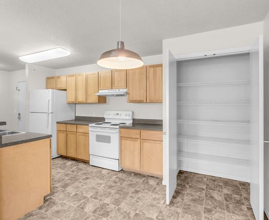 A kitchen with wooden cabinets and a white refrigerator.