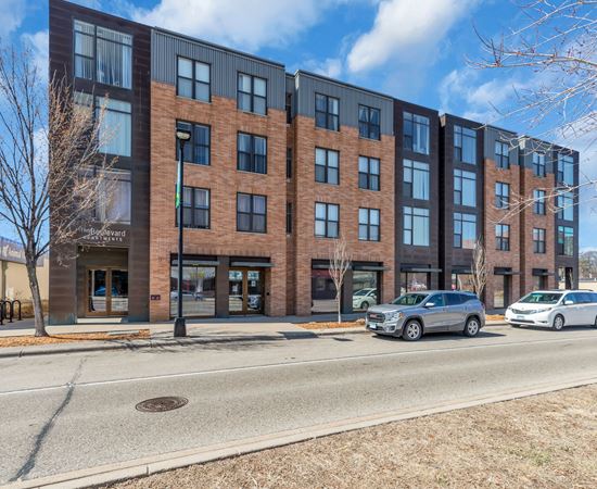 A modern brick building with a parking lot in front.