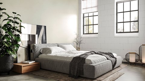 A modern bedroom with a large bed and a potted plant.