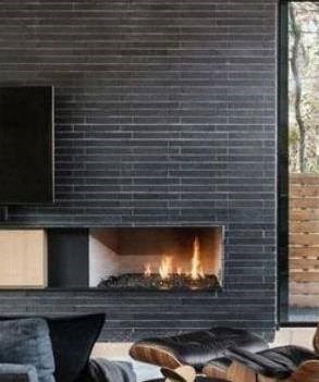 A modern fireplace with a black frame and a fire burning inside.