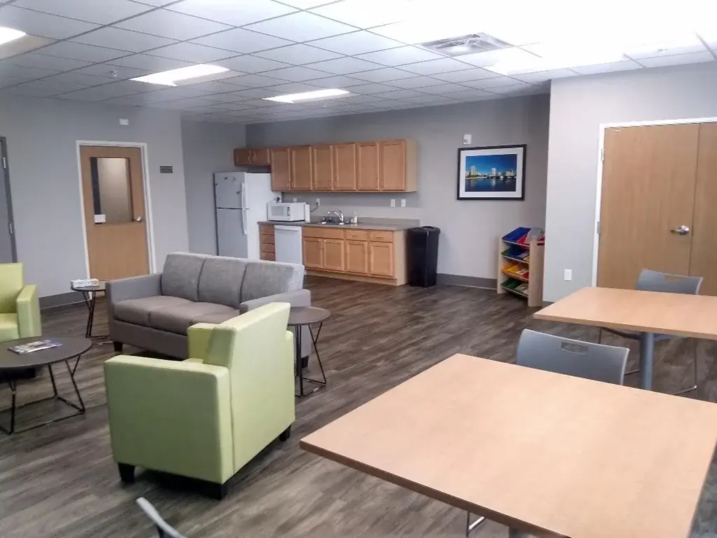 A room with a kitchenette and seating area.