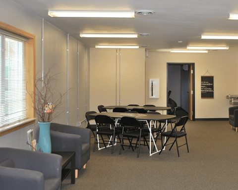 A conference room with a table, chairs, and a blue vase.