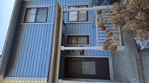 A blue building with windows and a balcony.