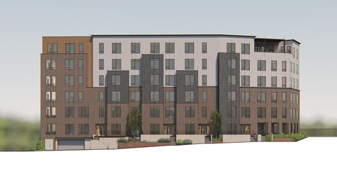 A large, modern apartment building with multiple balconies and a mix of window sizes.
