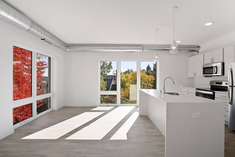 A kitchen with white cabinets and a white counter top.
