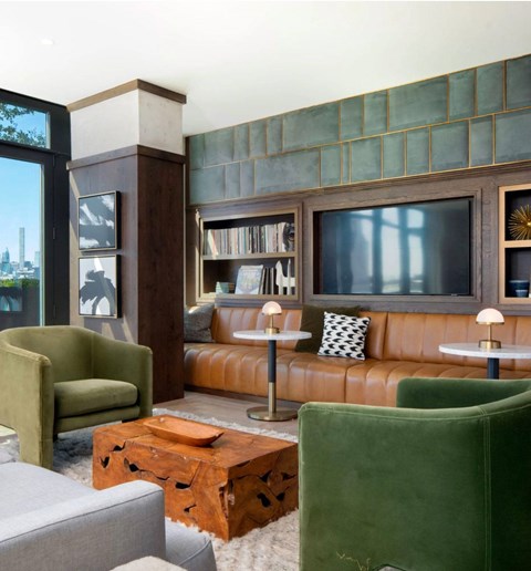 A living room with a green chair and a brown leather couch.