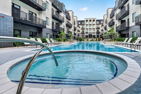 A swimming pool in a courtyard surrounded by apartment buildings.