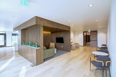A modern office space with a wooden reception desk and chairs.
