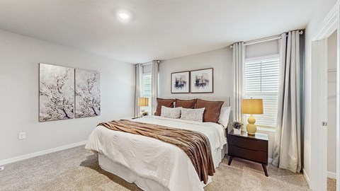 A bedroom with a large bed and two framed pictures on the wall.