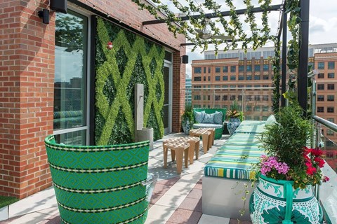 A green planter with a white design is on a balcony.