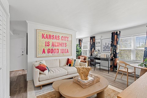 A living room with a couch and a poster that says "Kansas City is always a good idea".
