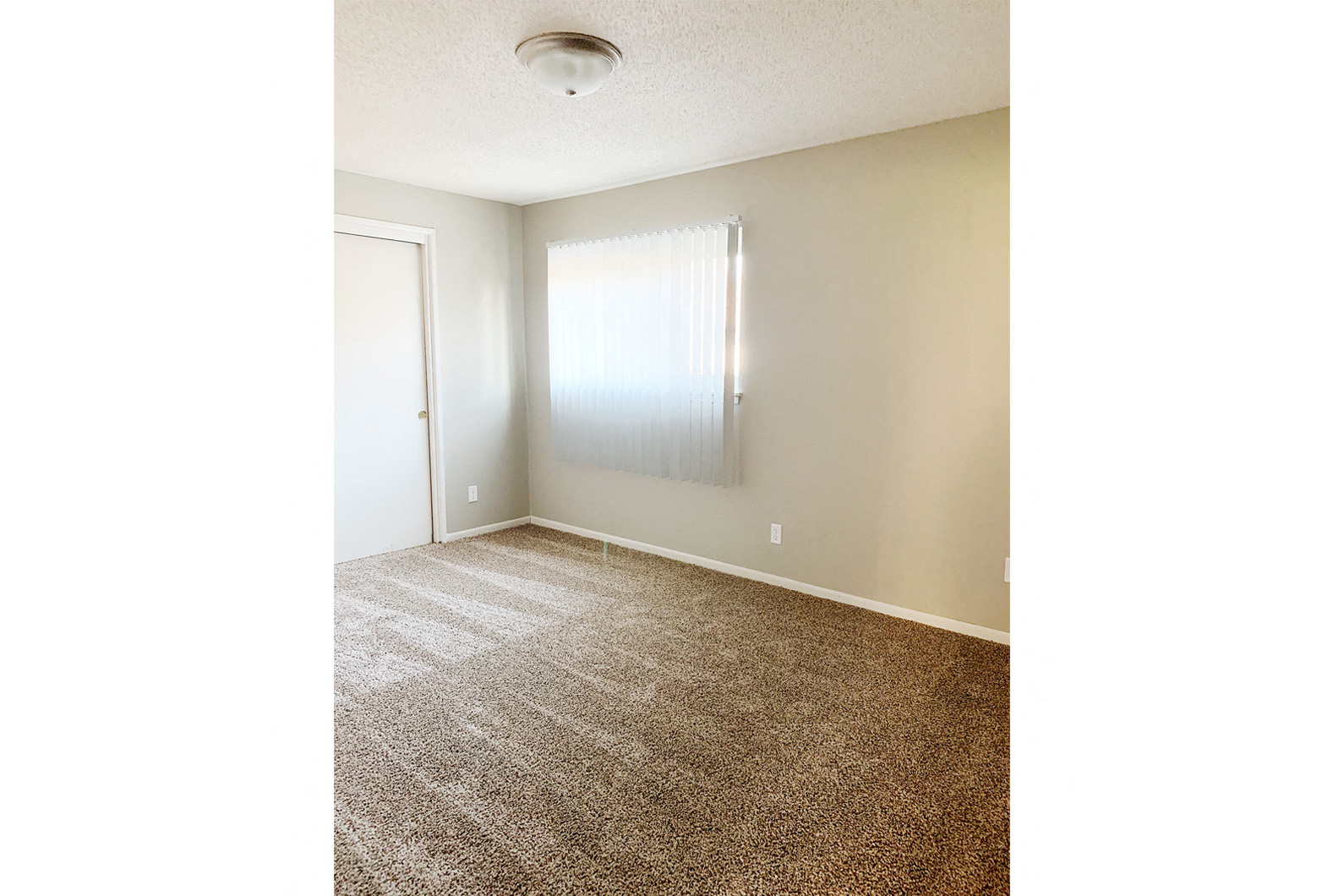 an empty room with carpet and a window