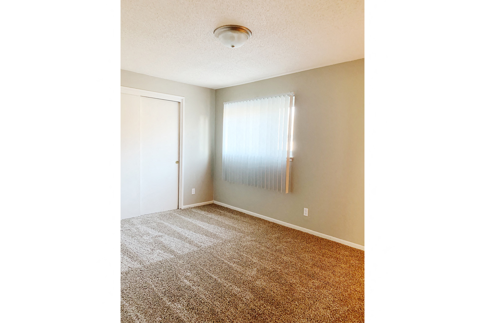 an empty room with a window and a curtain