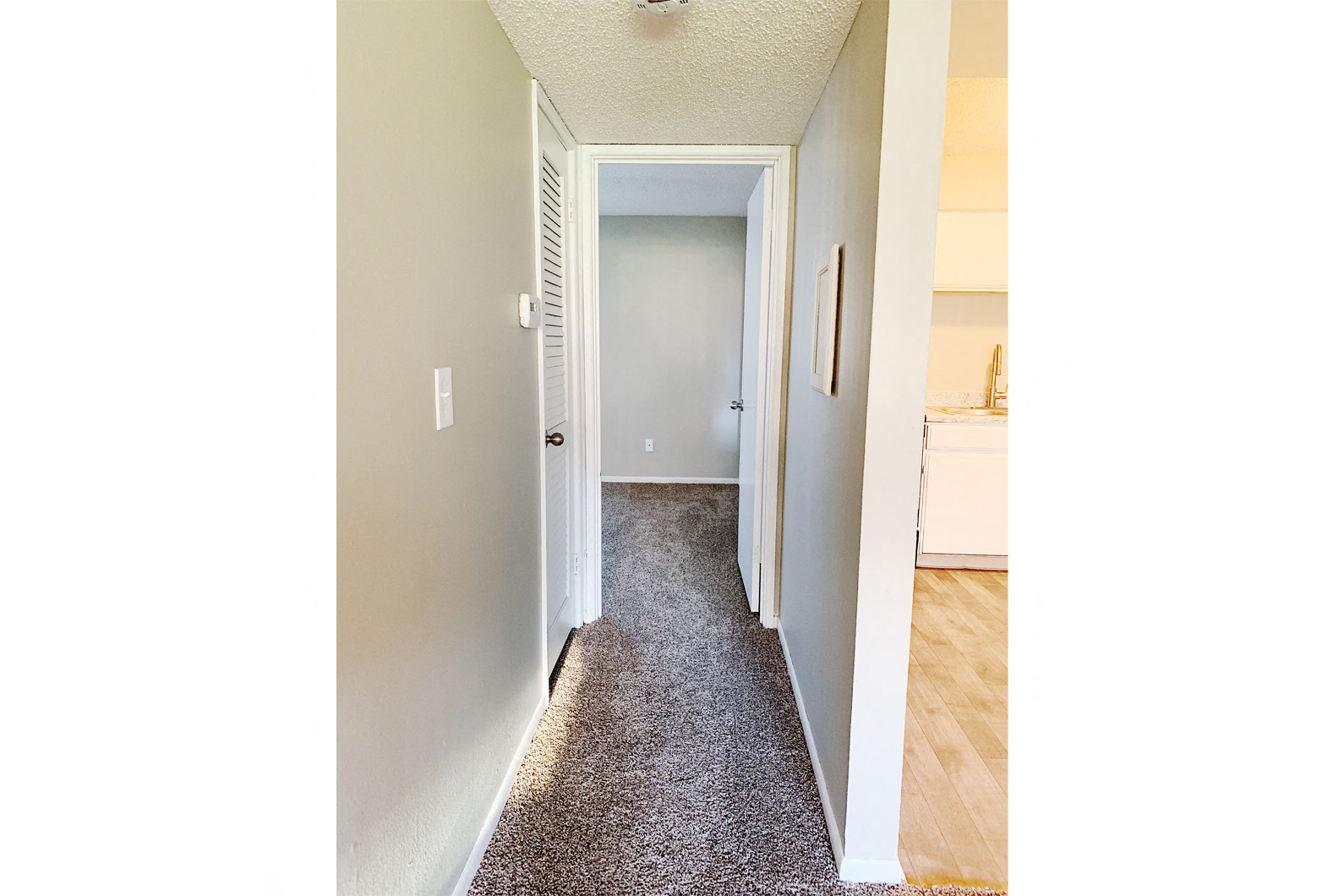 an empty hallway with a door to a closet