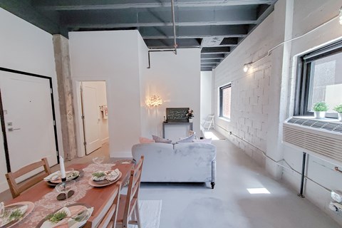 A dining room with a wooden table set for two.