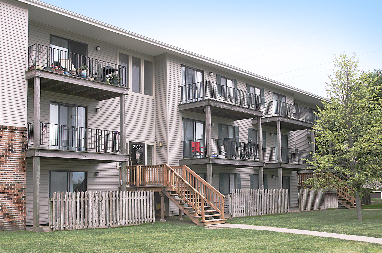 an apartment building with balconies and a wooden staircase