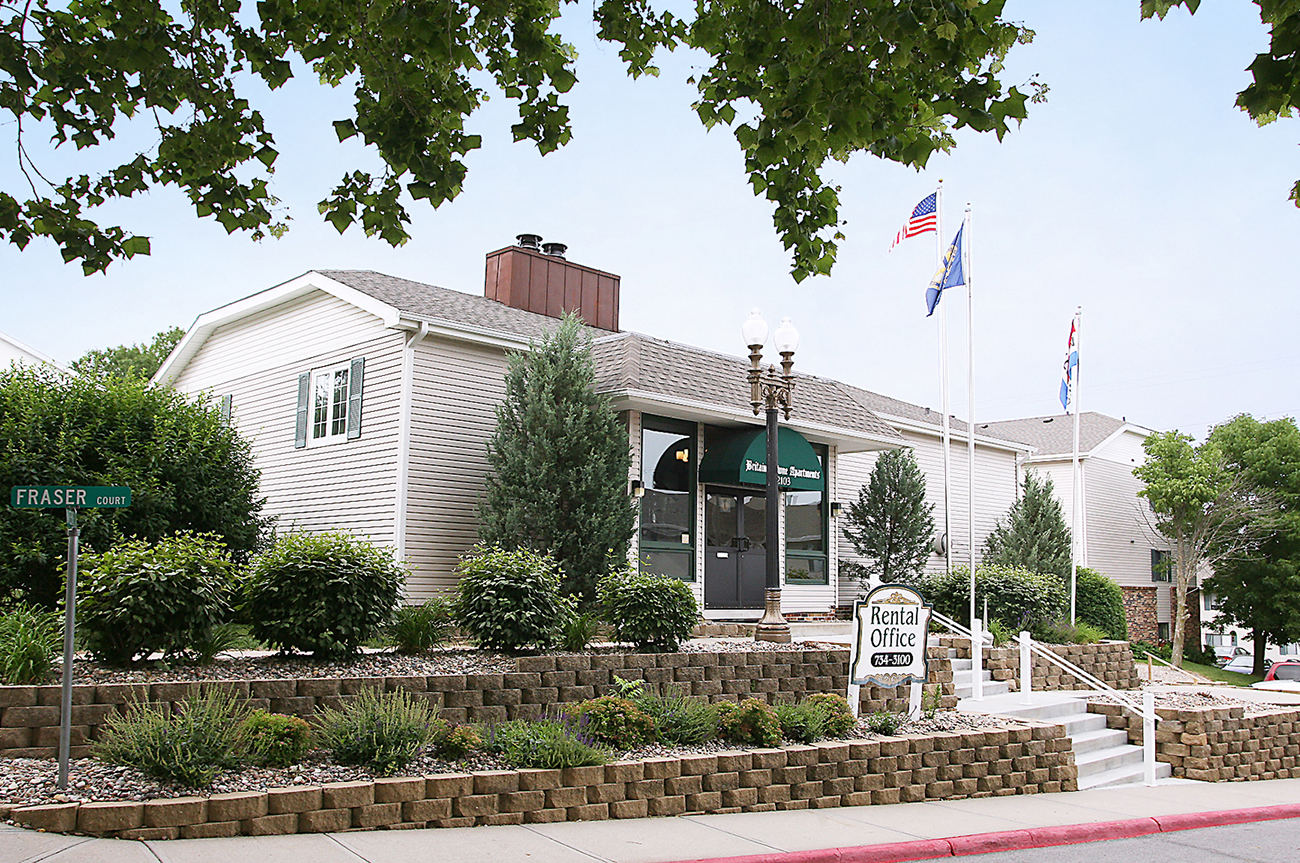 a white house with flags and a sign in front of it