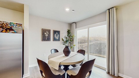 A dining room with a table and chairs.