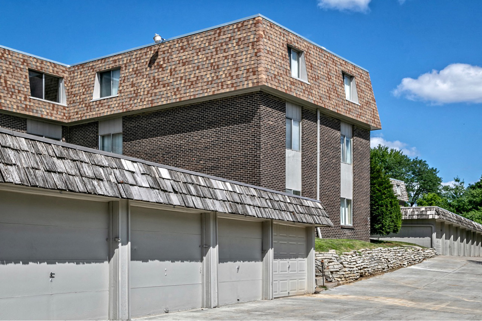the side of a brick building with a row of garage doors