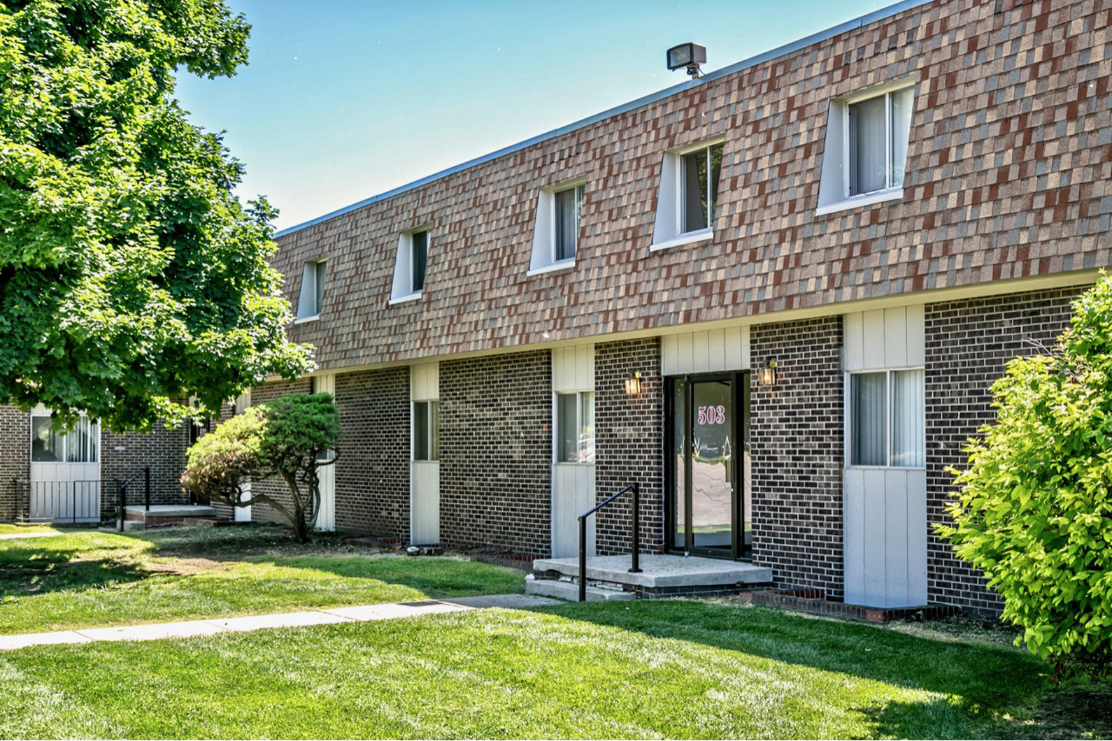 a brick building with a lawn in front of it