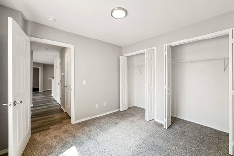 A spacious room with white walls and a carpeted floor.