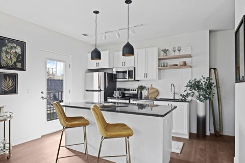 A kitchen with a black countertop and white cabinets.