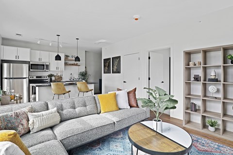 A grey couch with yellow pillows sits in a modern living room.