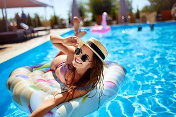 a woman laying on a raft in a swimming pool