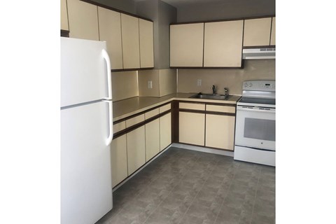 A kitchen with a white refrigerator, white oven, and white microwave.