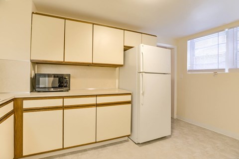 A kitchen with a microwave on the counter and a refrigerator.