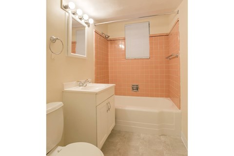 A bathroom with a toilet, sink, and bathtub.
