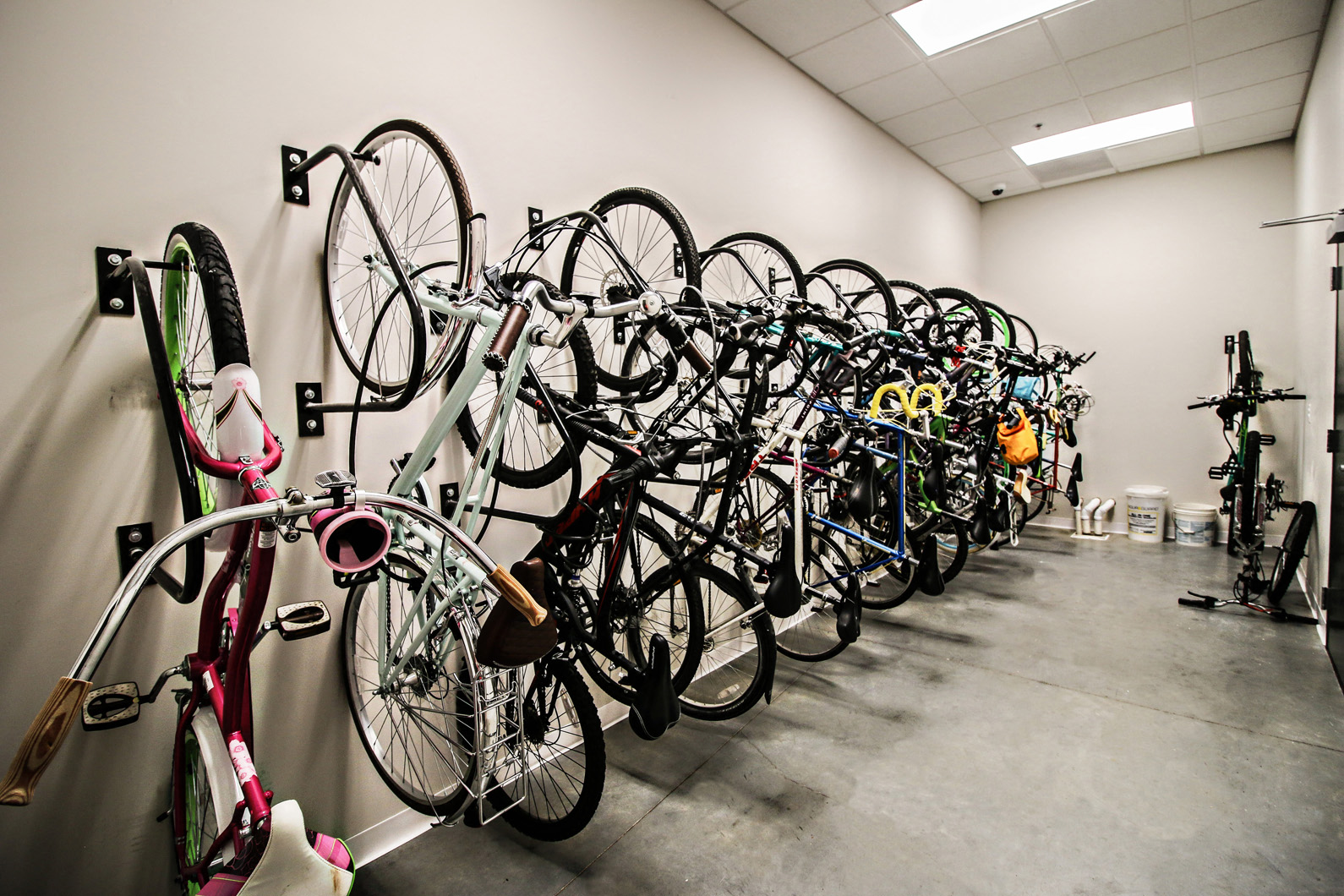a row of bikes hanging on a wall in a bike shop