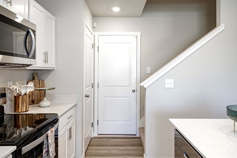 A kitchen with white cabinets and a black stove top.