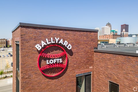 A red sign on a brick building that says Ballyard Lofts.