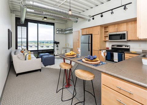 A kitchen with a bar stool and a counter with food on it.