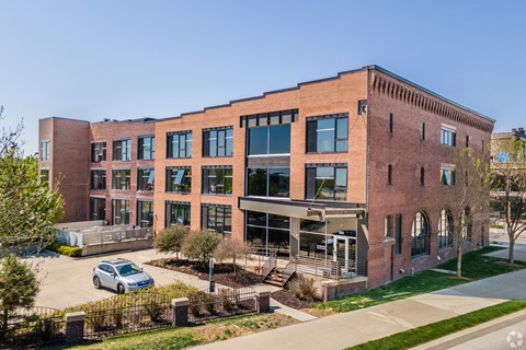 A large red brick building with a parking lot in front.