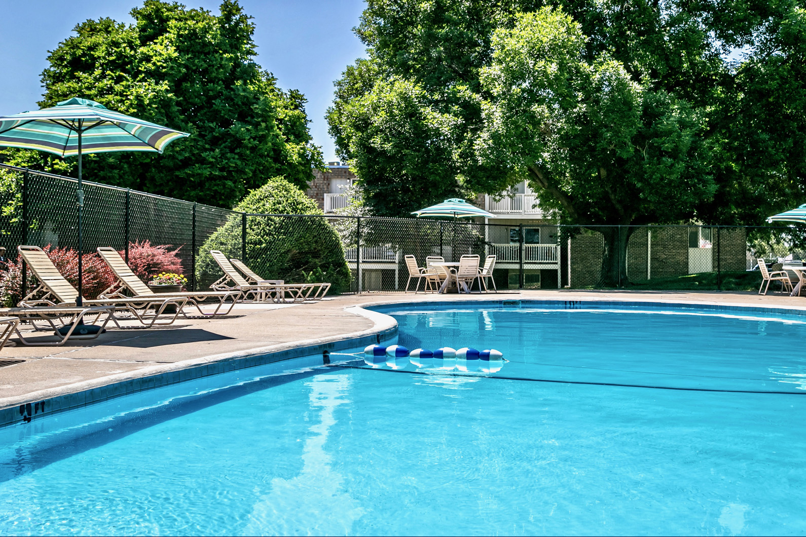 a swimming pool with chairs and umbrellas next to a resort style pool
