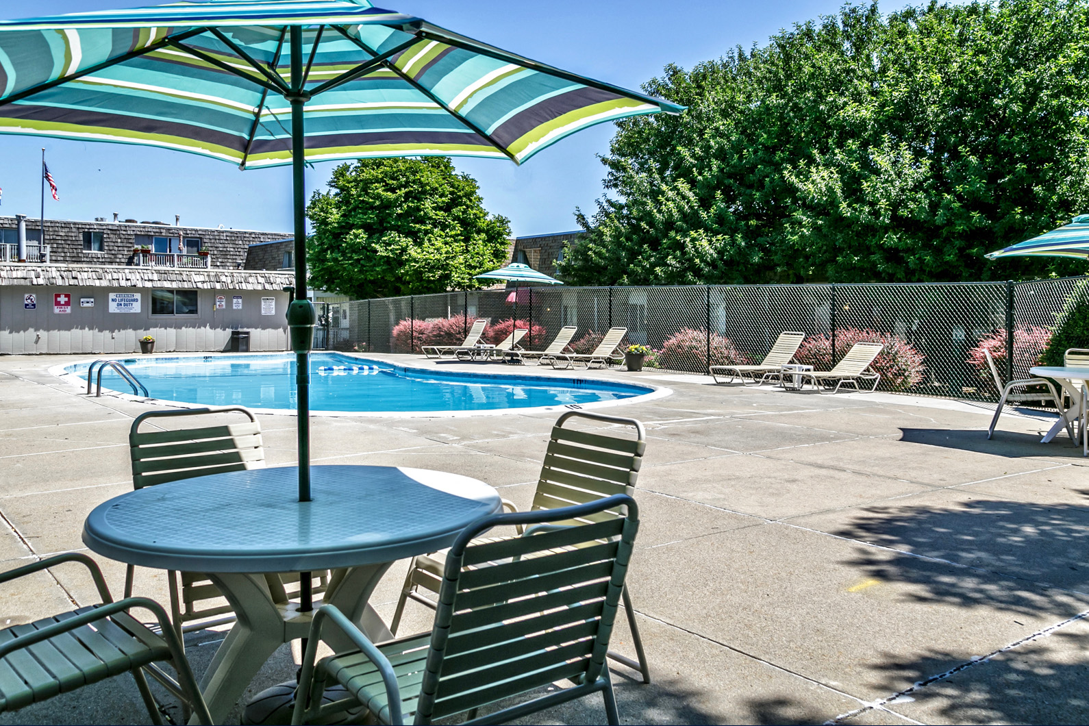 a patio with a pool and tables with umbrellas