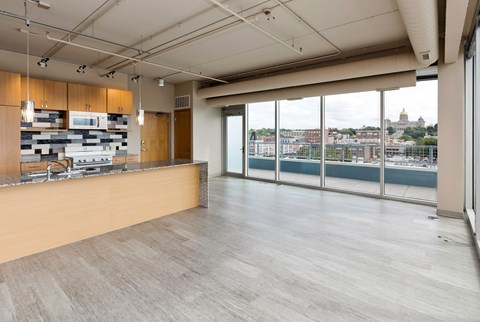 A modern kitchen with a long counter and a view of the city.