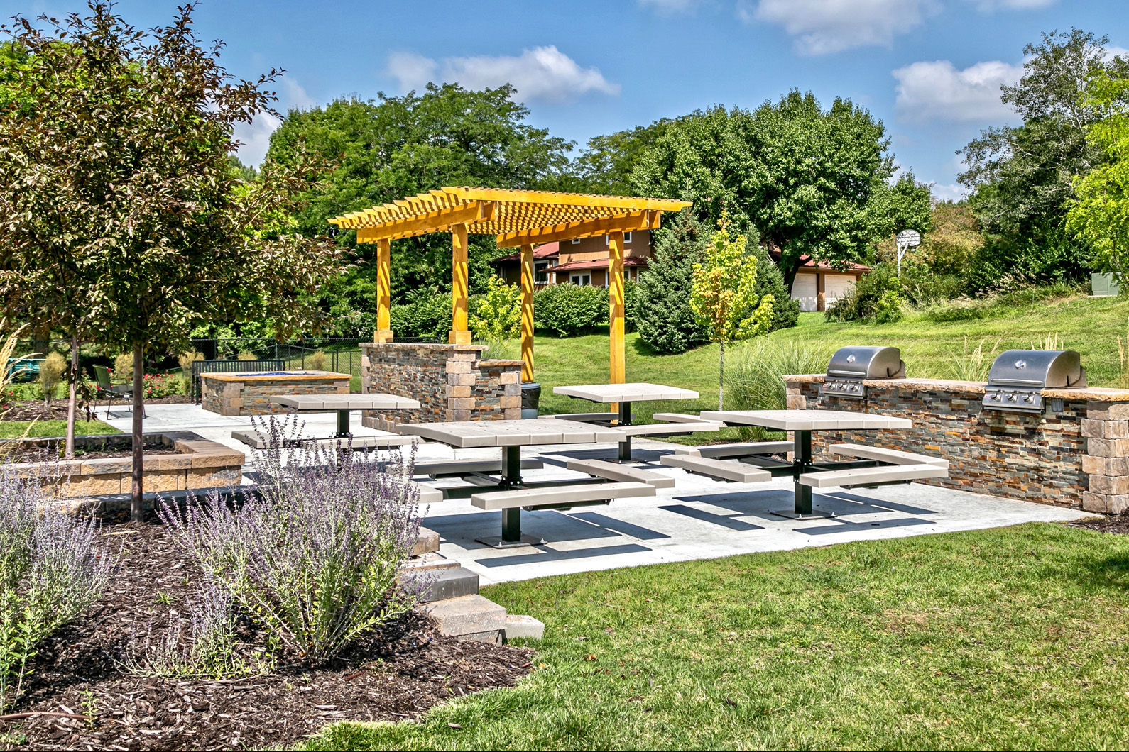 Outdoor picnic area with community grills and fireplaces at Club at Highland Park Apartments, Omaha, NE