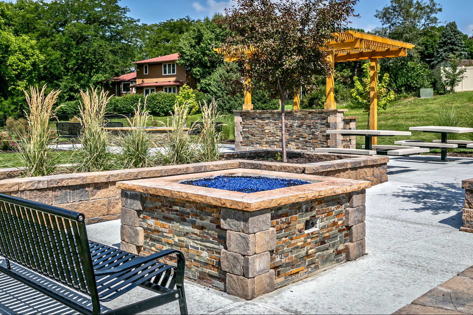 Outdoor picnic area with community grills and fireplaces at Club at Highland Park Apartments, Omaha, NE