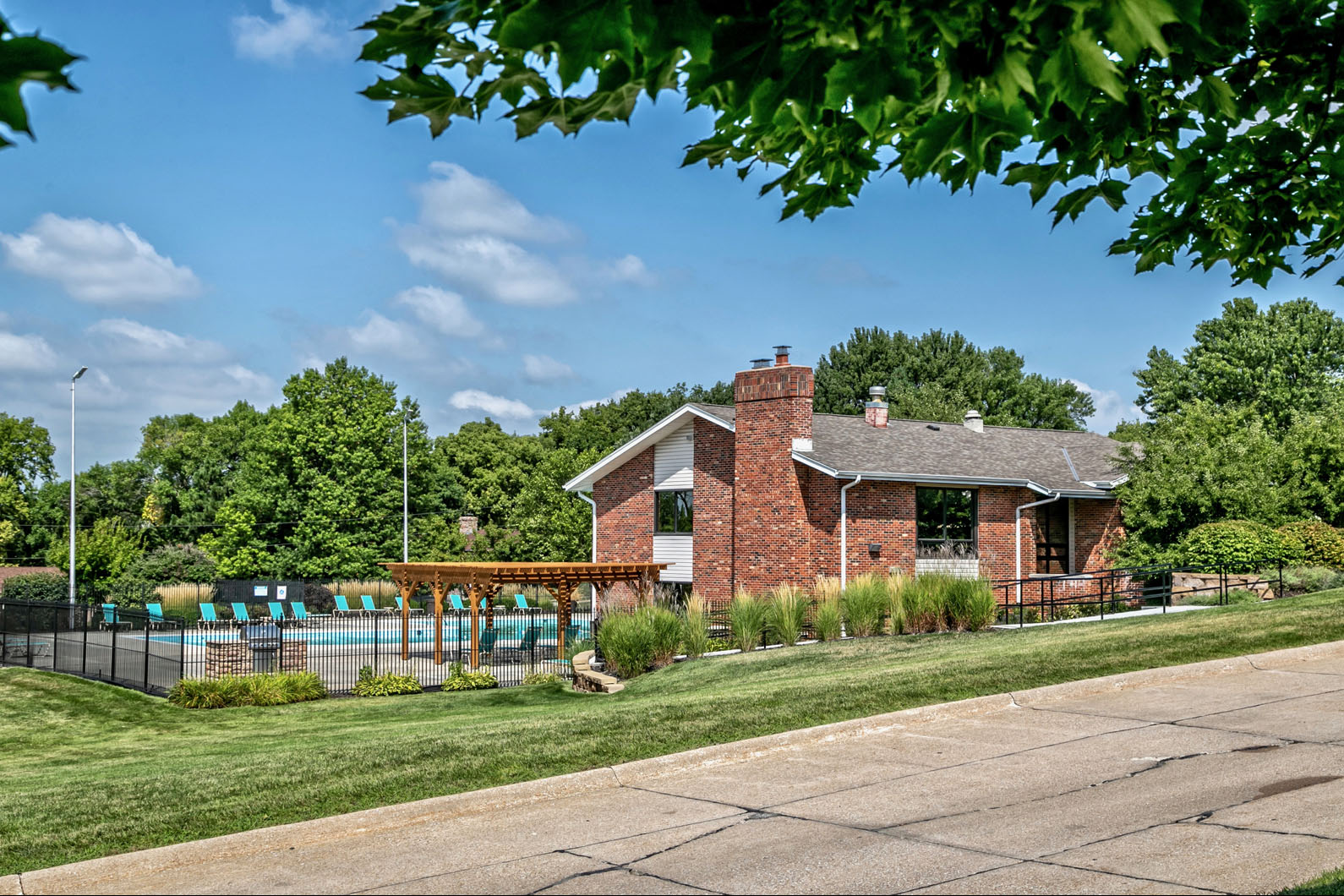 Clubhouse exterior with olympic sized swimming pool at Club at Highland Park Apartments, Omaha, NE