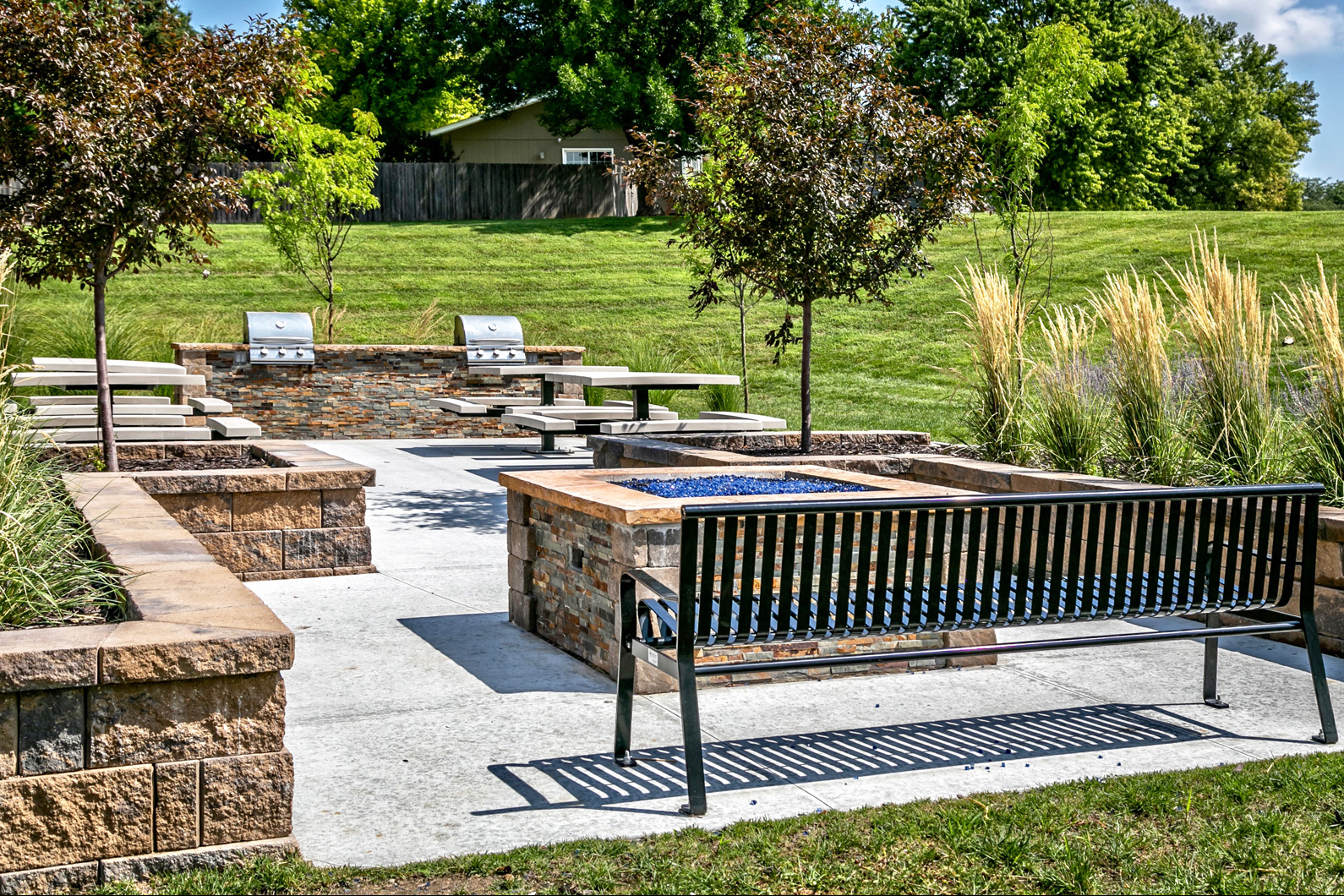 Outdoor picnic area with community grills and fireplaces at Club at Highland Park Apartments, Omaha, NE